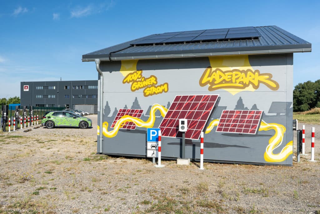 Charging park in the foreground. E-cars and AKKU SYS company building in the background