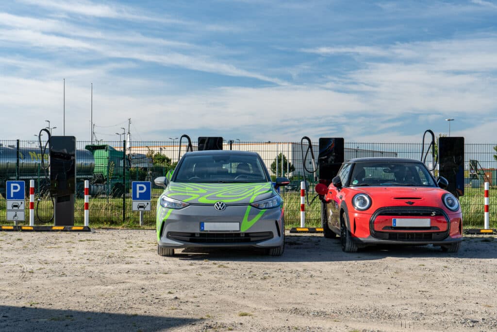 E cars at Hyper Charger charging stations, blue sky and buildings in the background.